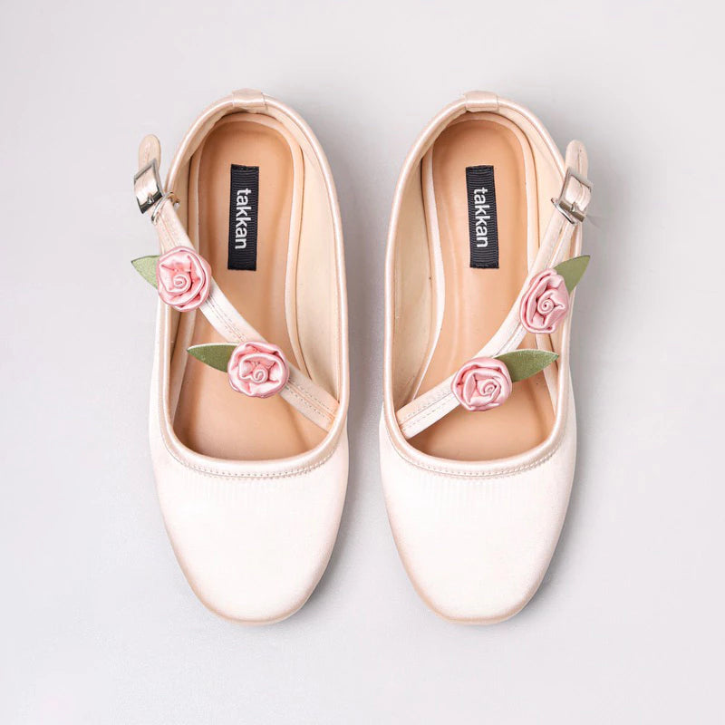 A closer look at Achi Mary Jane flatshoes featuring delicate pink rose accents on the straps, paired with white ribbed socks for a sweet and charming style.
