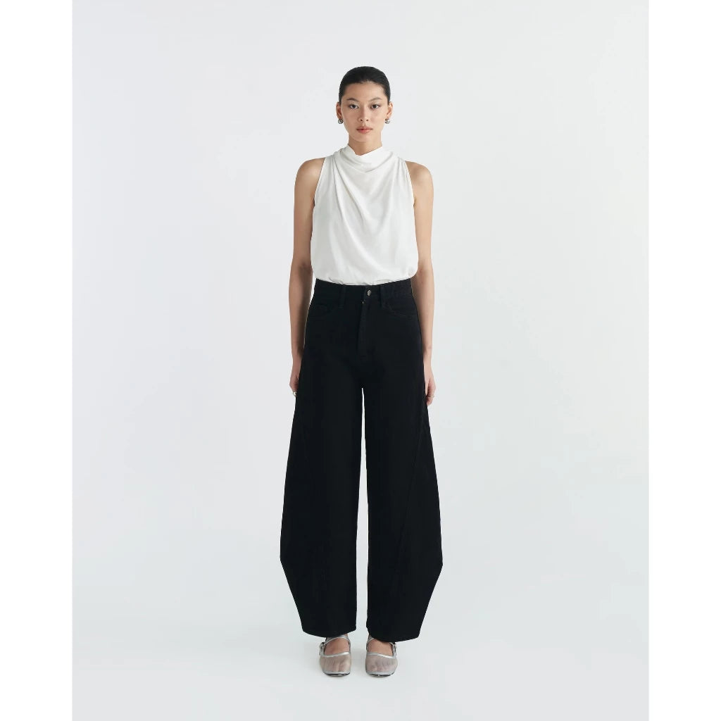 Person wearing a white sleeveless top and black wide-leg pants by Achete de Nous on a white background