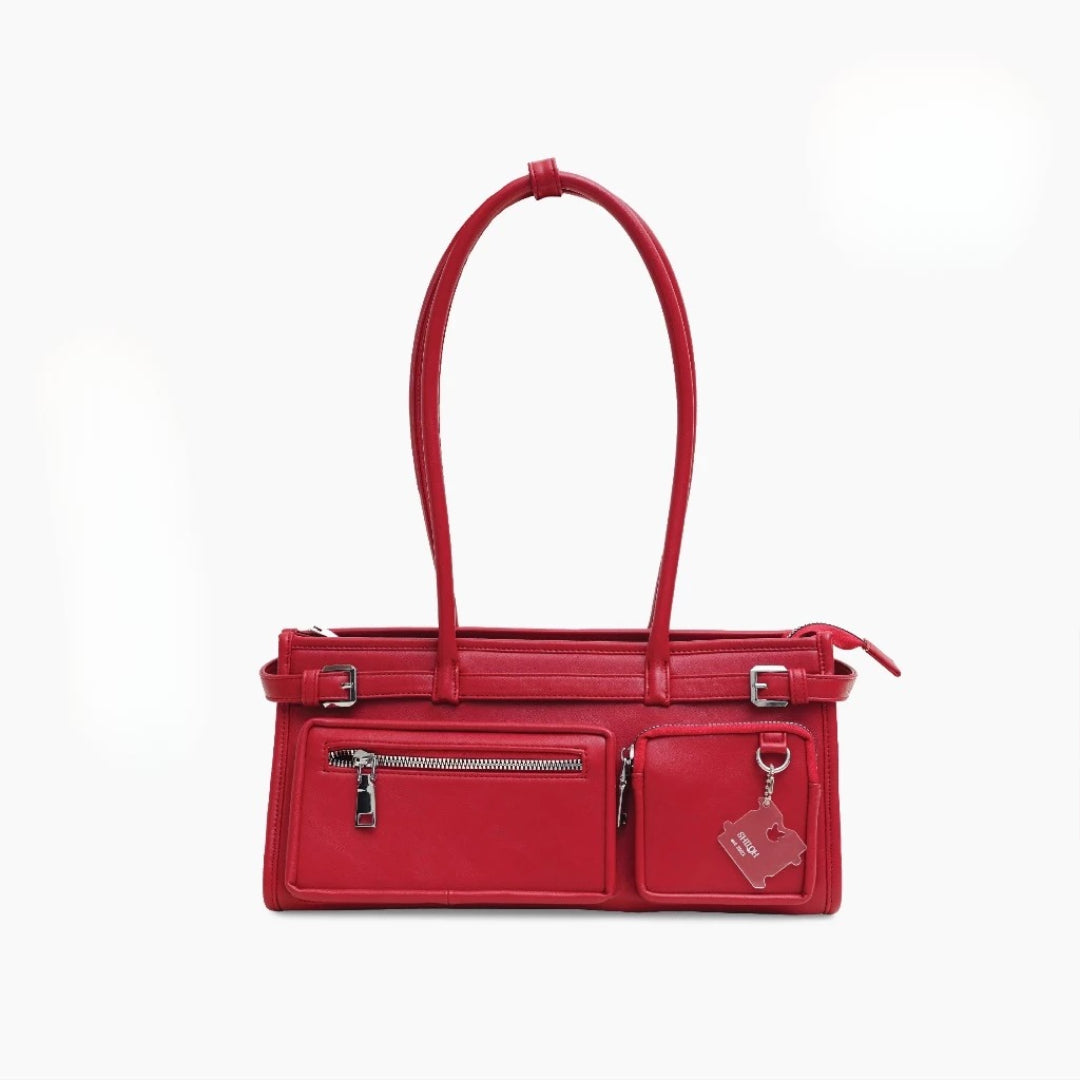 Red handbag with multiple pockets and zippers on a white background
Tas tangan wanita berwarna merah dengan banyak saku dan resleting pada latar belakang putih
