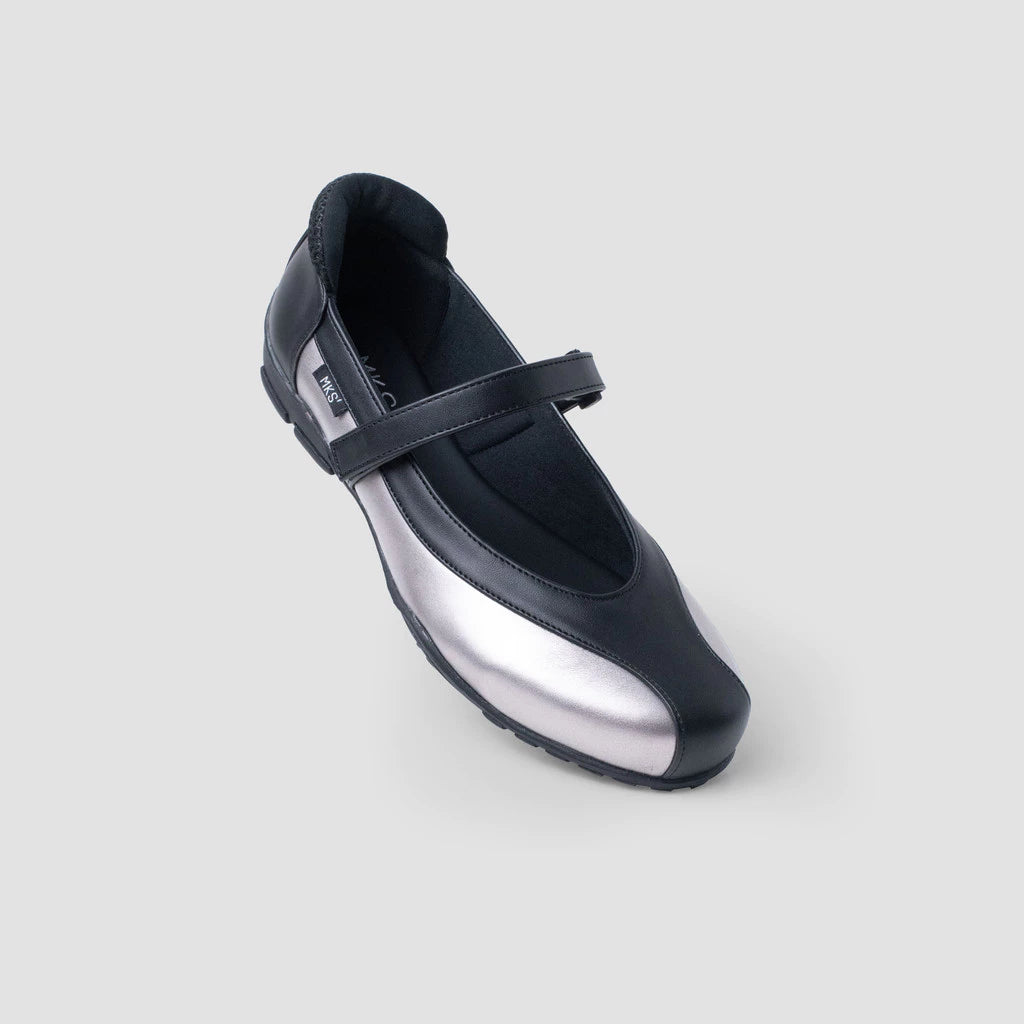 A silver and black flat shoes by MKS Shoes with a Mary Jane strap and a low heel, set on a white background.