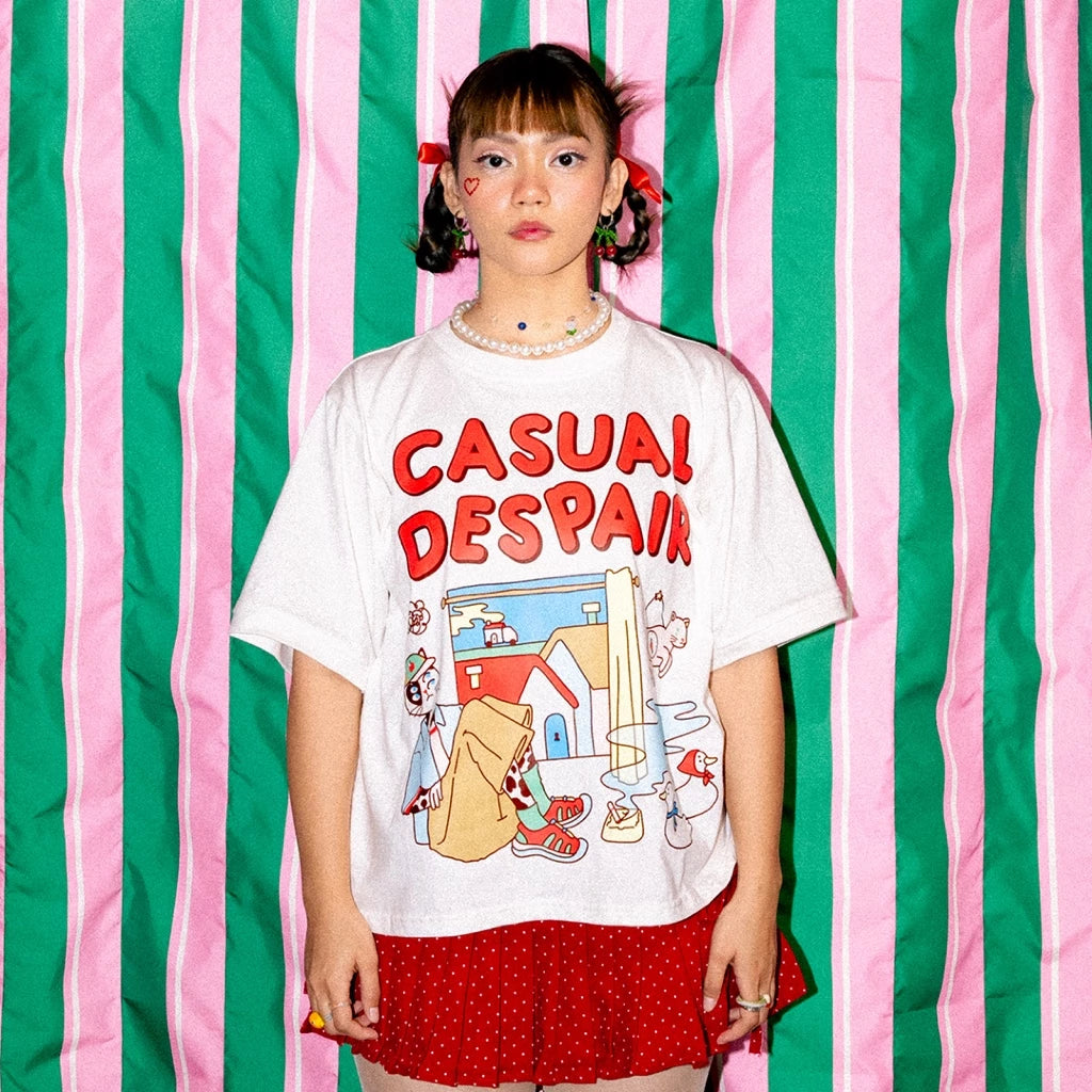 Person wearing a white t-shirt by Oh.Irv with colorful graphics and text against a striped green and pink background