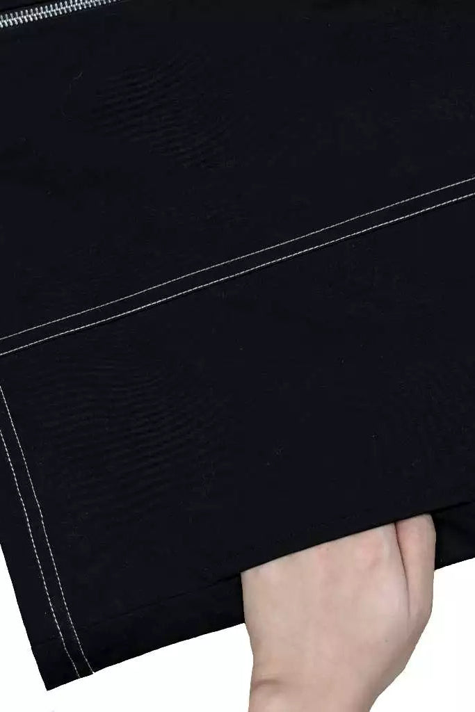 Close-up of a black work jacket with white stitching on a white background