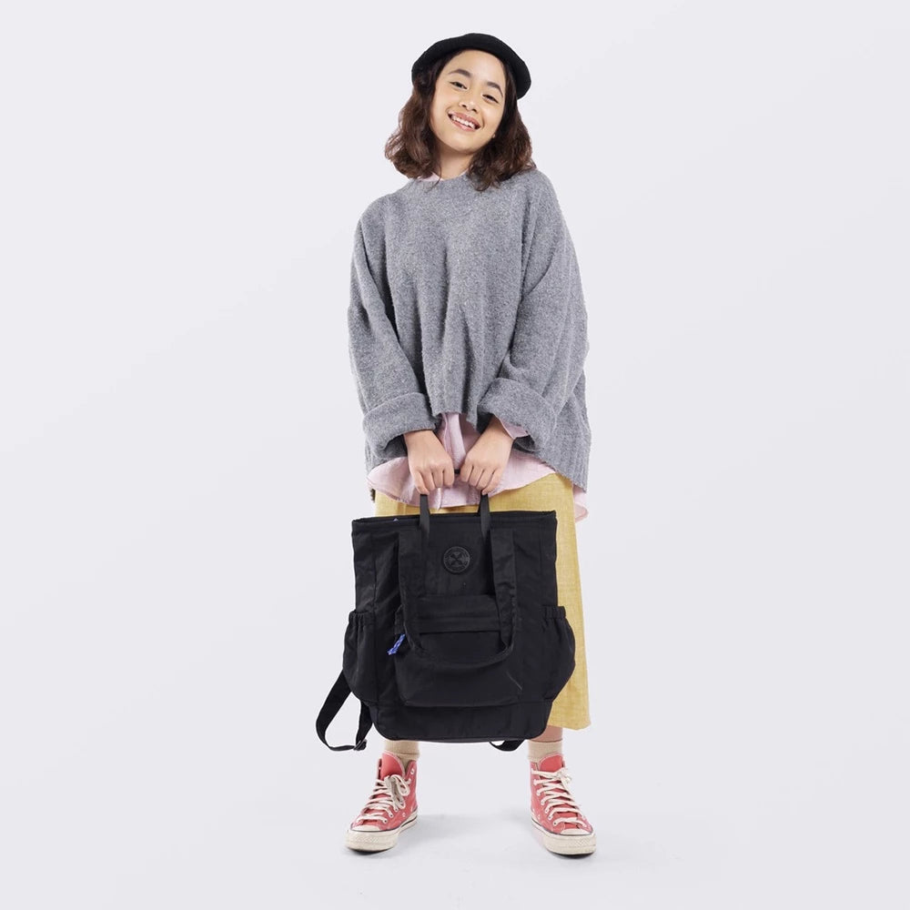 A person smiling and holding a black Exsport laptop totebag, standing against a white background.