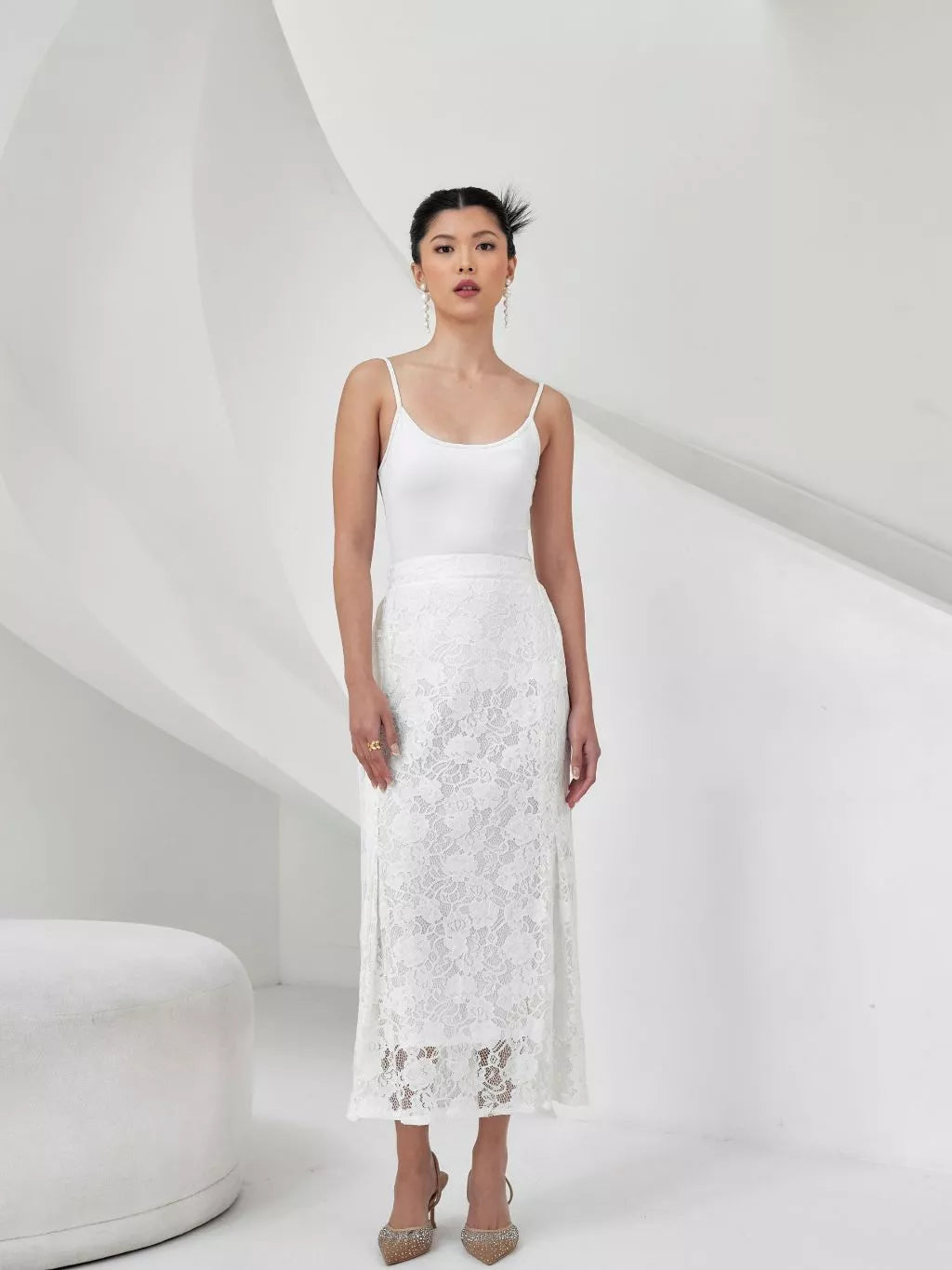 Woman wearing a white lace skirt against a white background