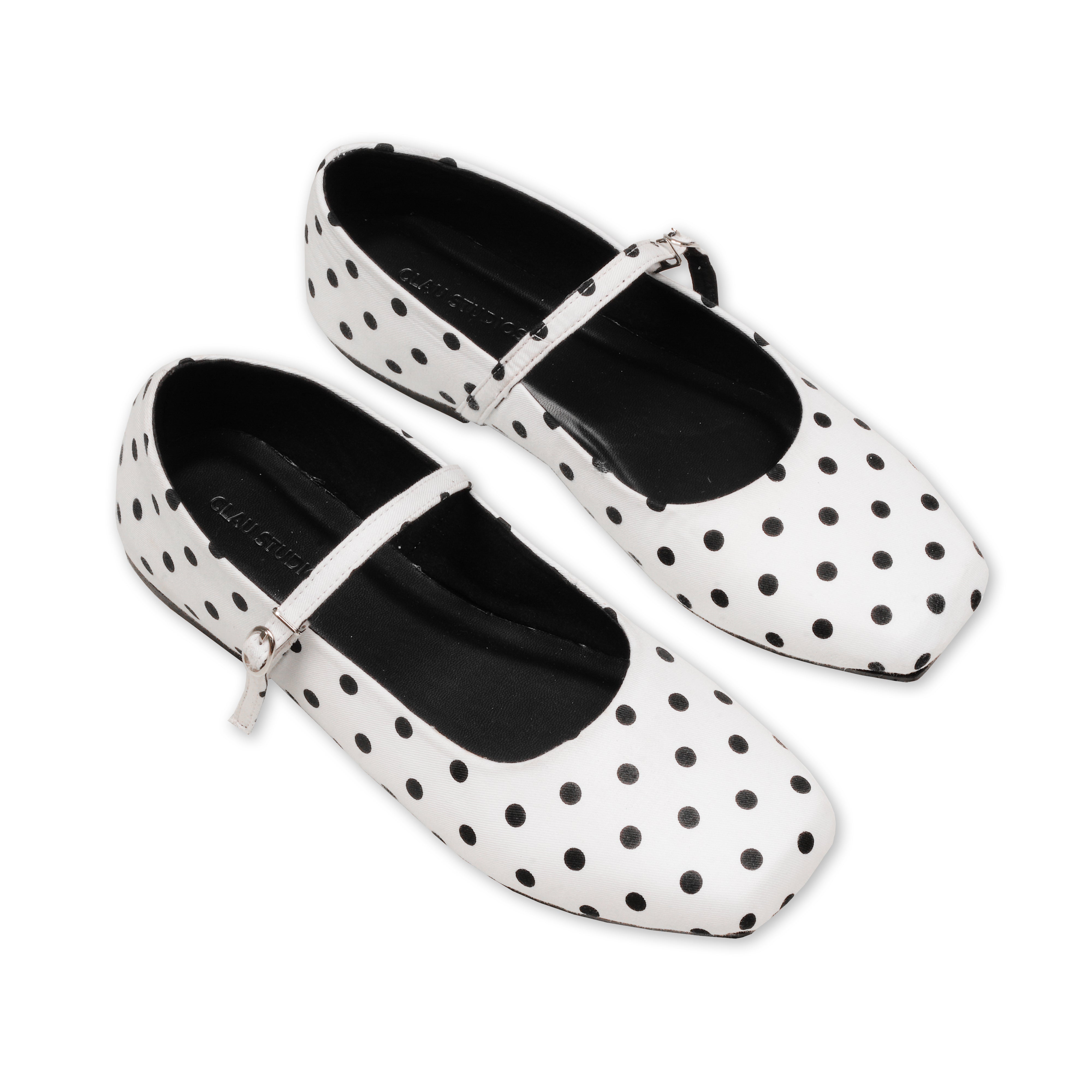 White flatshoes with black polka dots on a white background