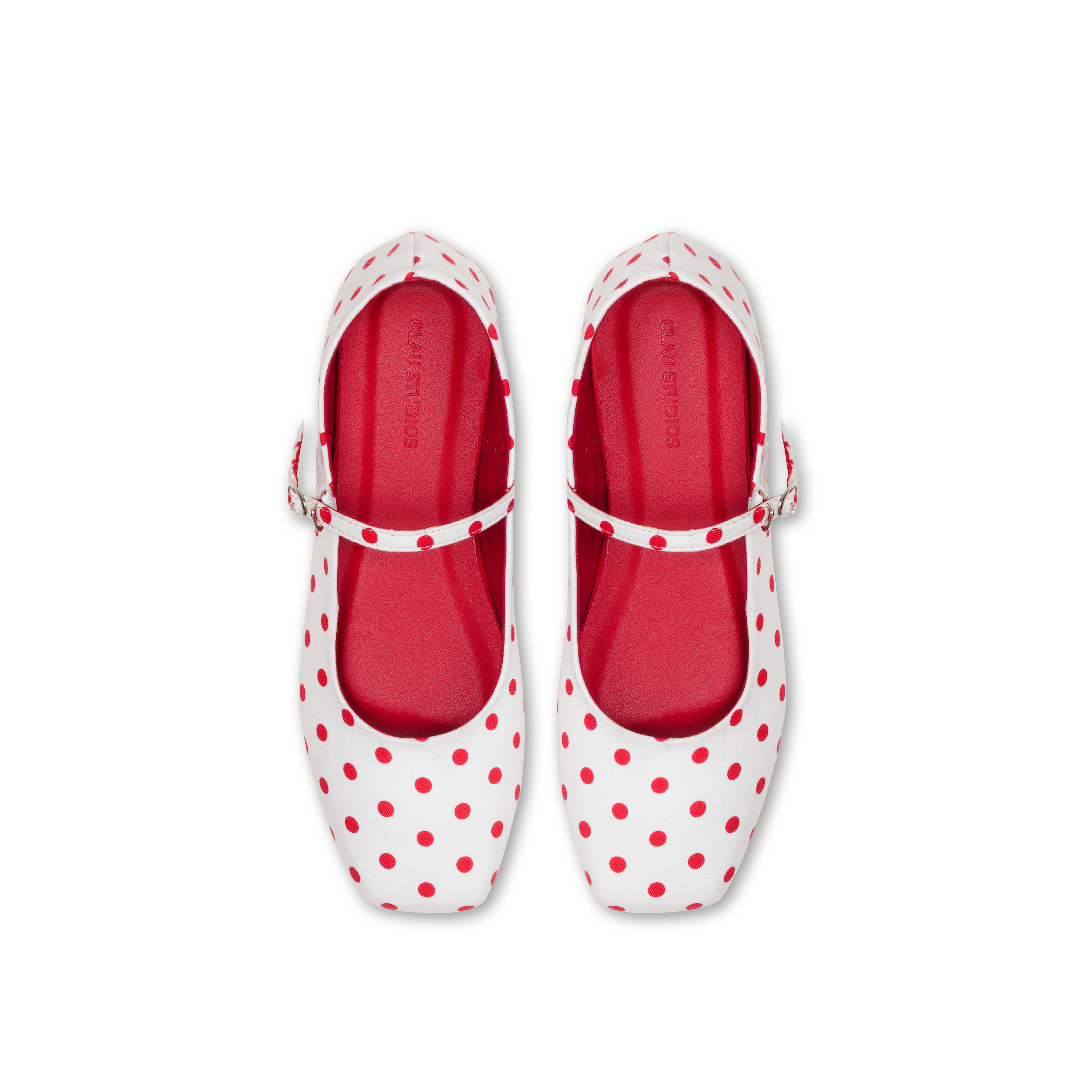 White flatshoes with red polka dots on a white background