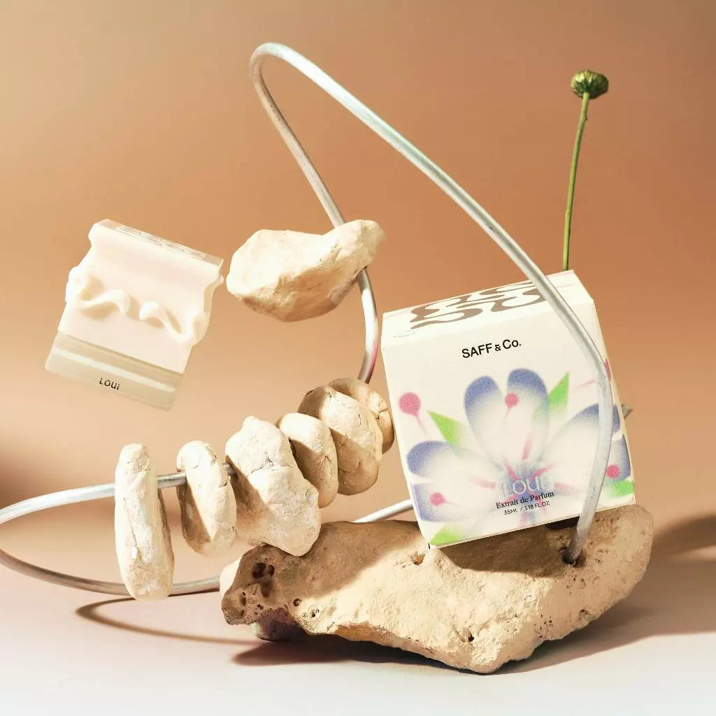 Loui perfume bottle with packaging from Saff & Co with decorative elements on a beige background