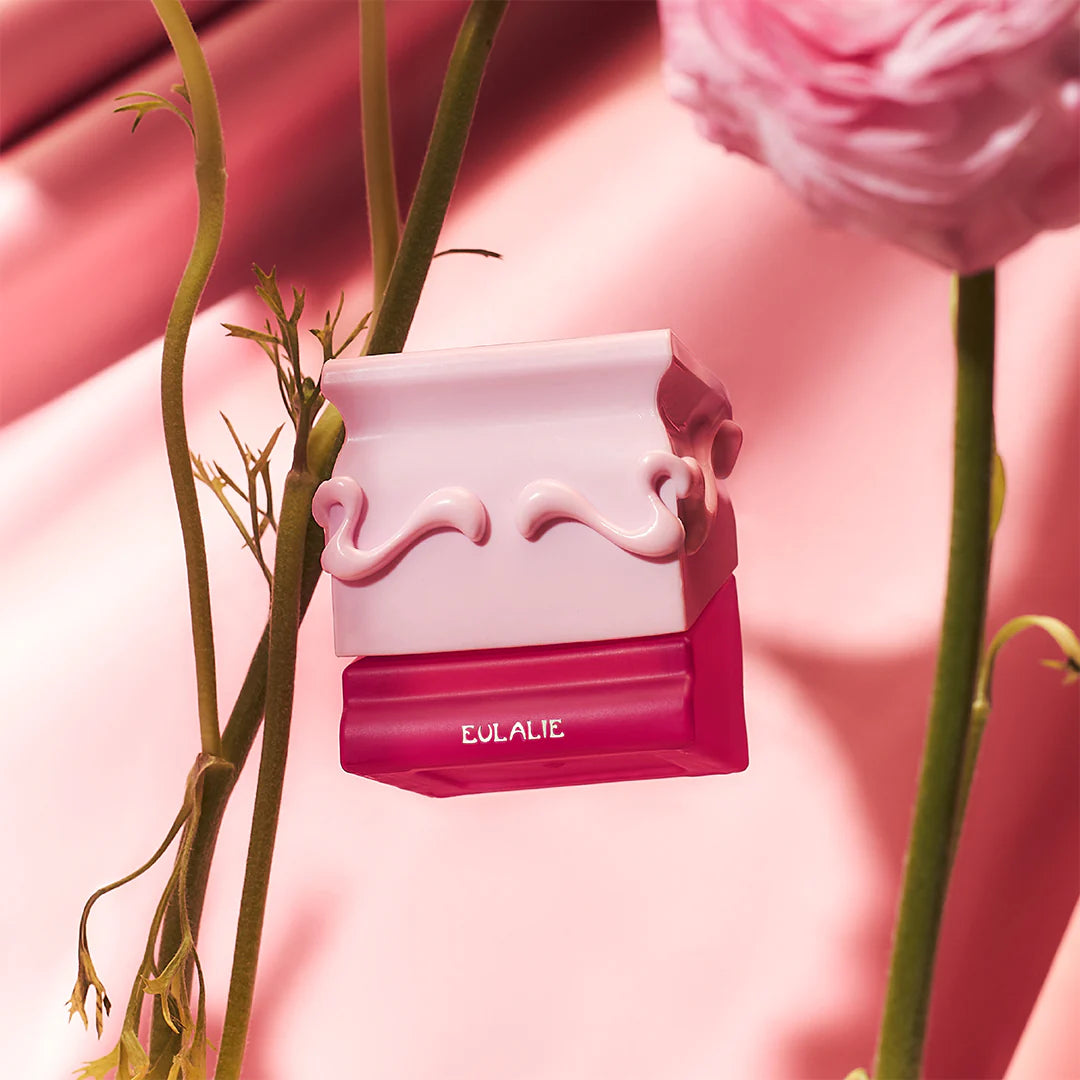 Pink and white Eulalie perfume bottle by Saff n Co with floral elements on a pink background