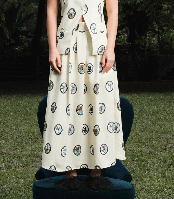 Person wearing a patterned cream skirt.
