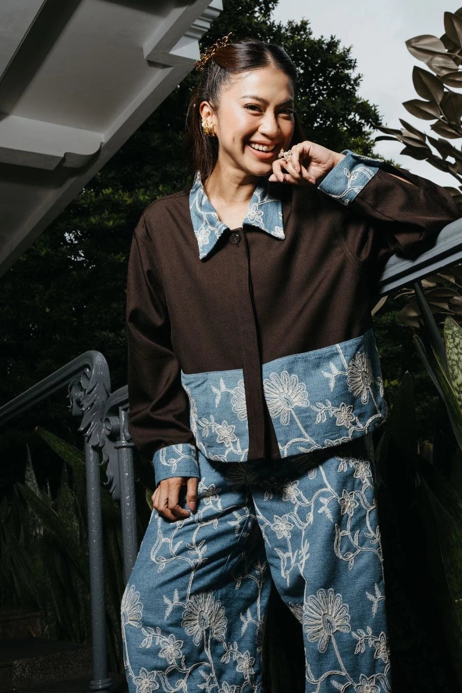 Person wearing a brown and blue floral jacket by LR Studio standing outdoors.