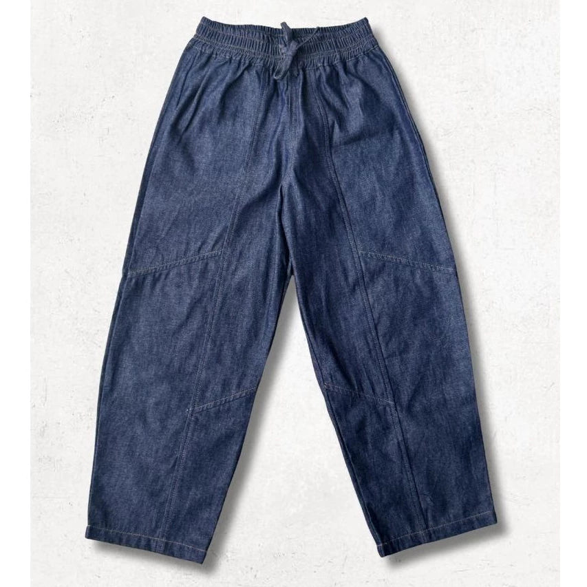 Blue denim barrel pants from Little Saints on a light gray background