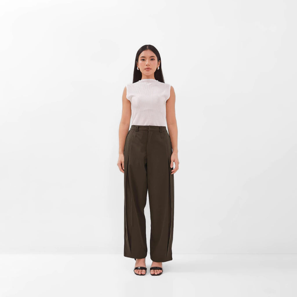 Woman wearing a white top and brown pants by Isoos Studios on a white background