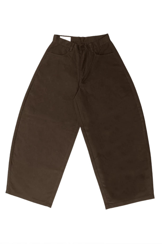 Brown barrel pants for women featuring a high-waist fit and exaggerated curved-leg silhouette. Designed with a structured oversized shape, wide legs, and tapered hem, these women’s barrel pants offer a modern minimalist look suitable for casual and contemporary styling.