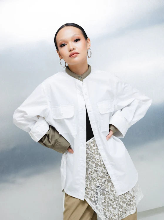Person wearing a white layered shirt by Wad Studio with a neutral background