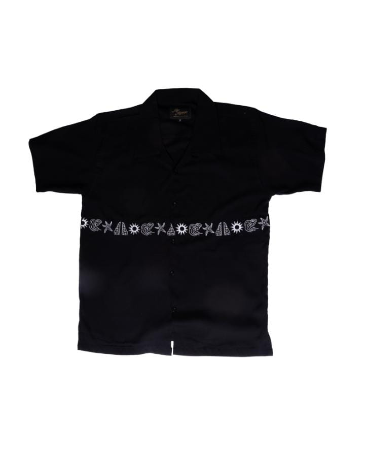 Black shirt by Manikan with decorative embroidered symbol on a white background
