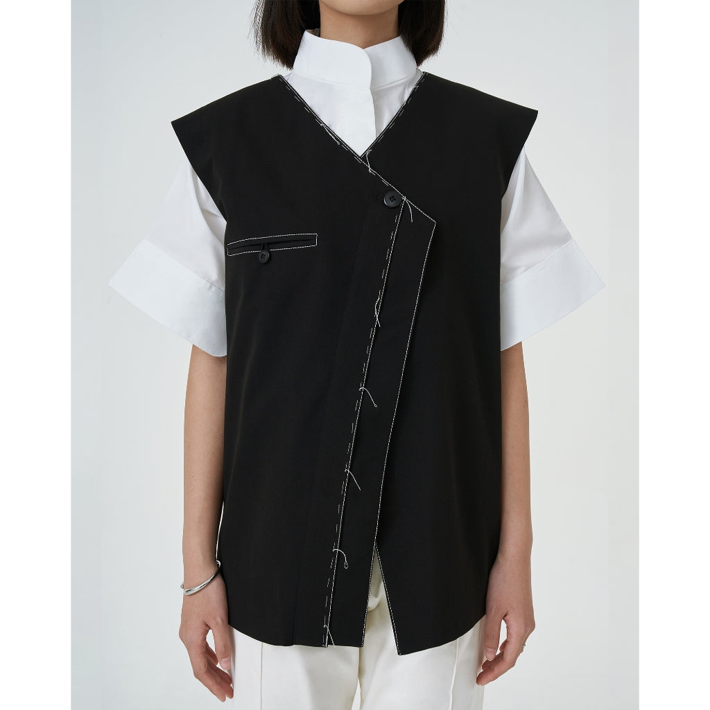 A closer look of Mille Vest from Acheté de Nouse, a black collarless vest with contrast handstitches details with hidden button on the inside.