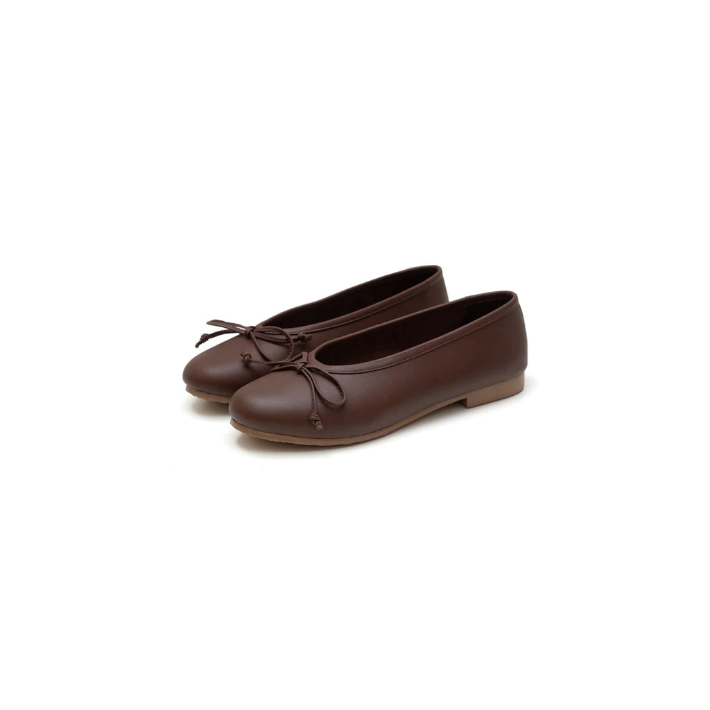 Pair of brown flat shoes by Cajsa on a white background
