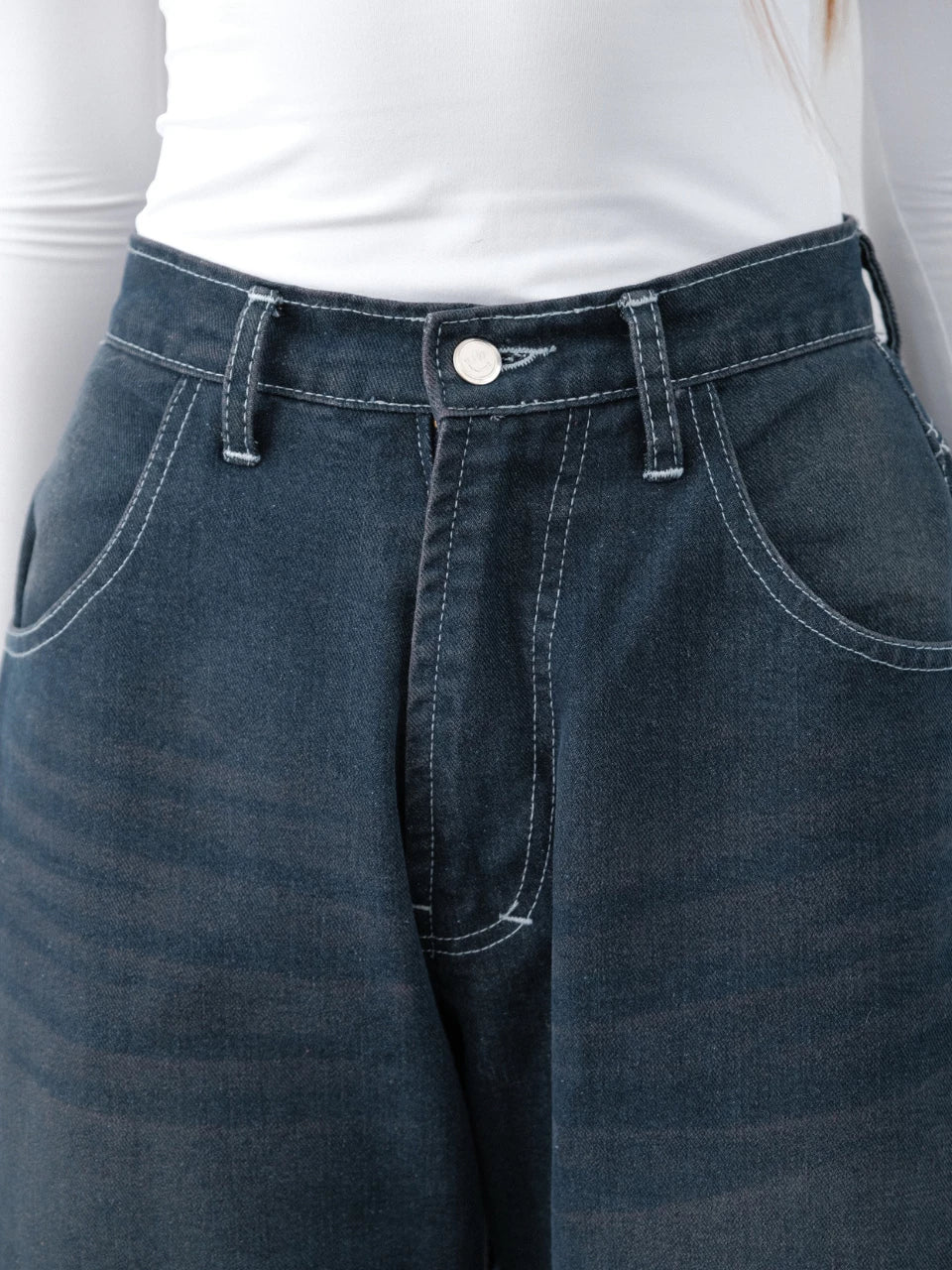 Close-up of Noa Barrel Denim Jeans Pants, a blue denim barrel pants from The Auctus, with a white shirt underneath