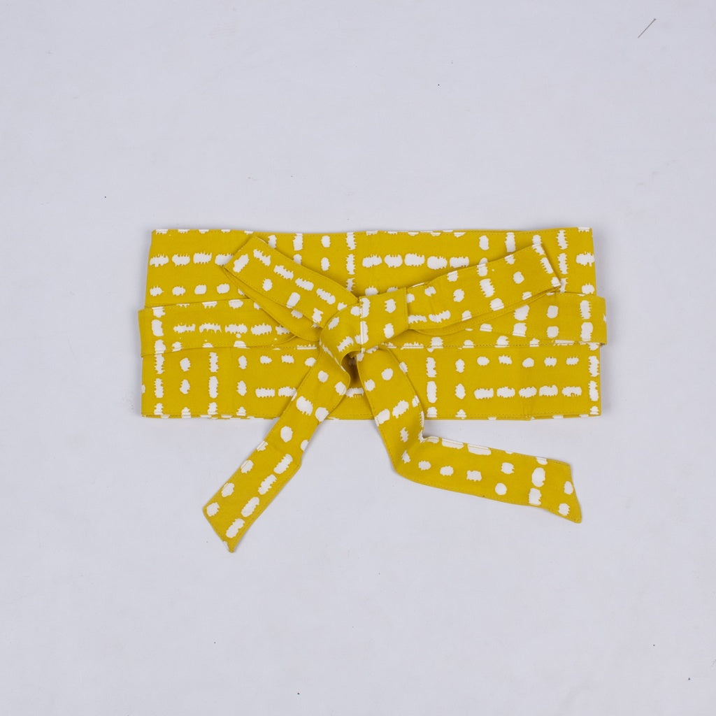 A yellow obi belt with a geometric pattern, made of rayon, tied in a bow.