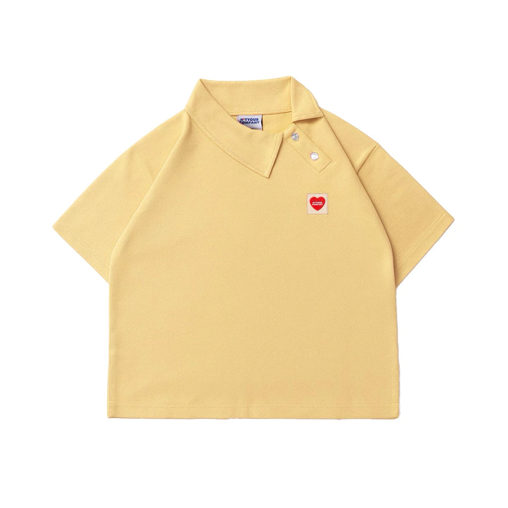 Yellow polo shirt with a small red heart logo by notyourcompany on a white background