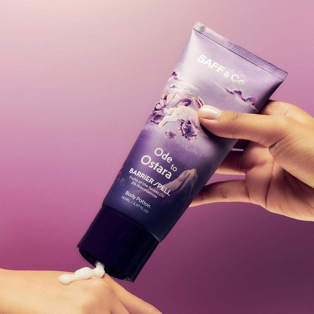 A person's hands holding a pump bottle of Saff & Co. Body Potion named 'Ode to Ostara' with a purple label, applying the product onto their forearm.