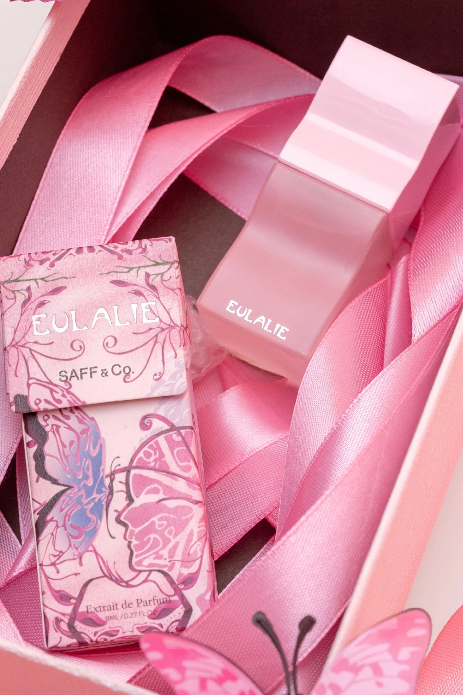 Pink perfume bottle with butterfly design and ribbon in a box by Saff n Co, featuring the label 'Eulalie'.