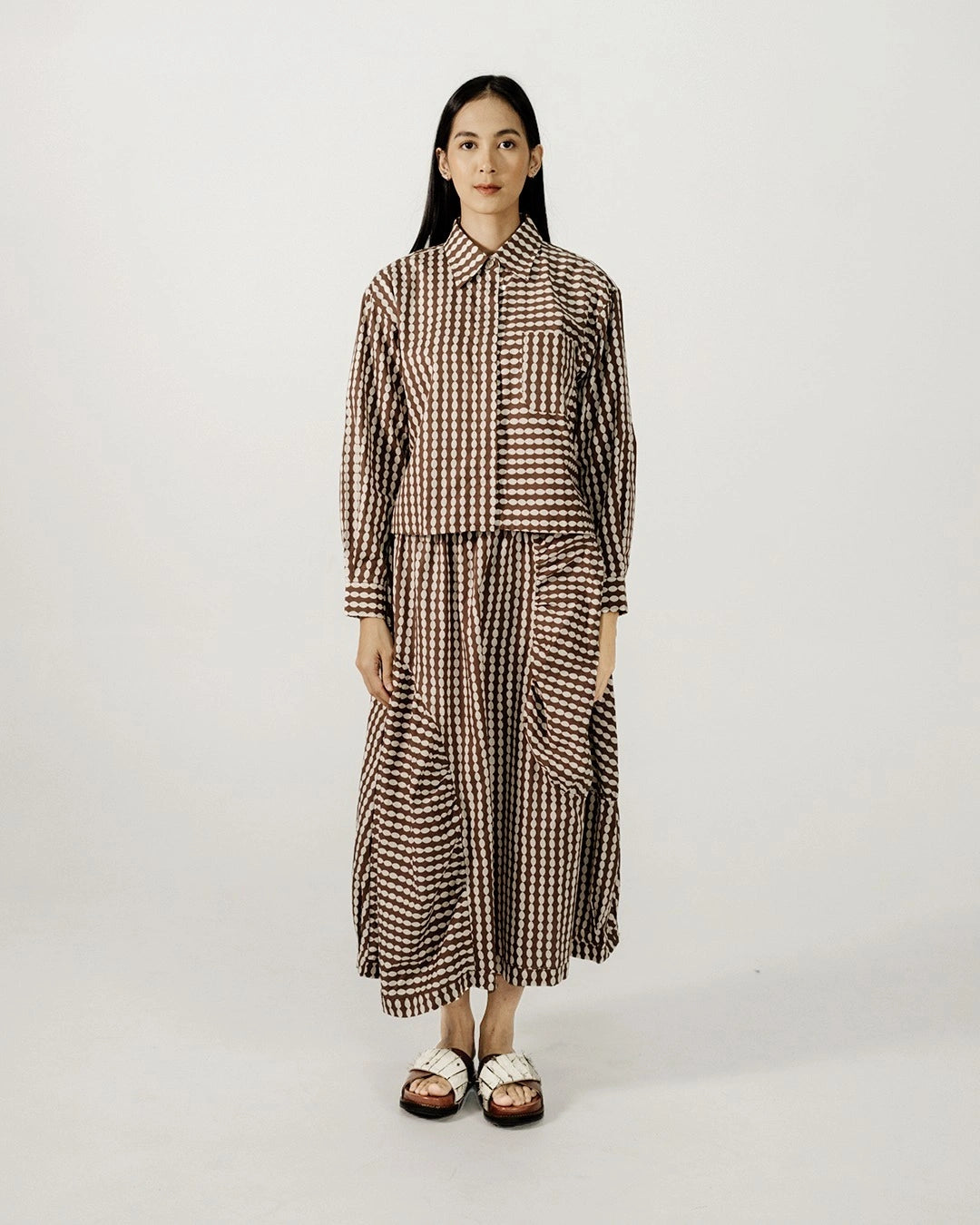 Woman wearing a brown checkered longsleeves shirt by Damakara on a white background