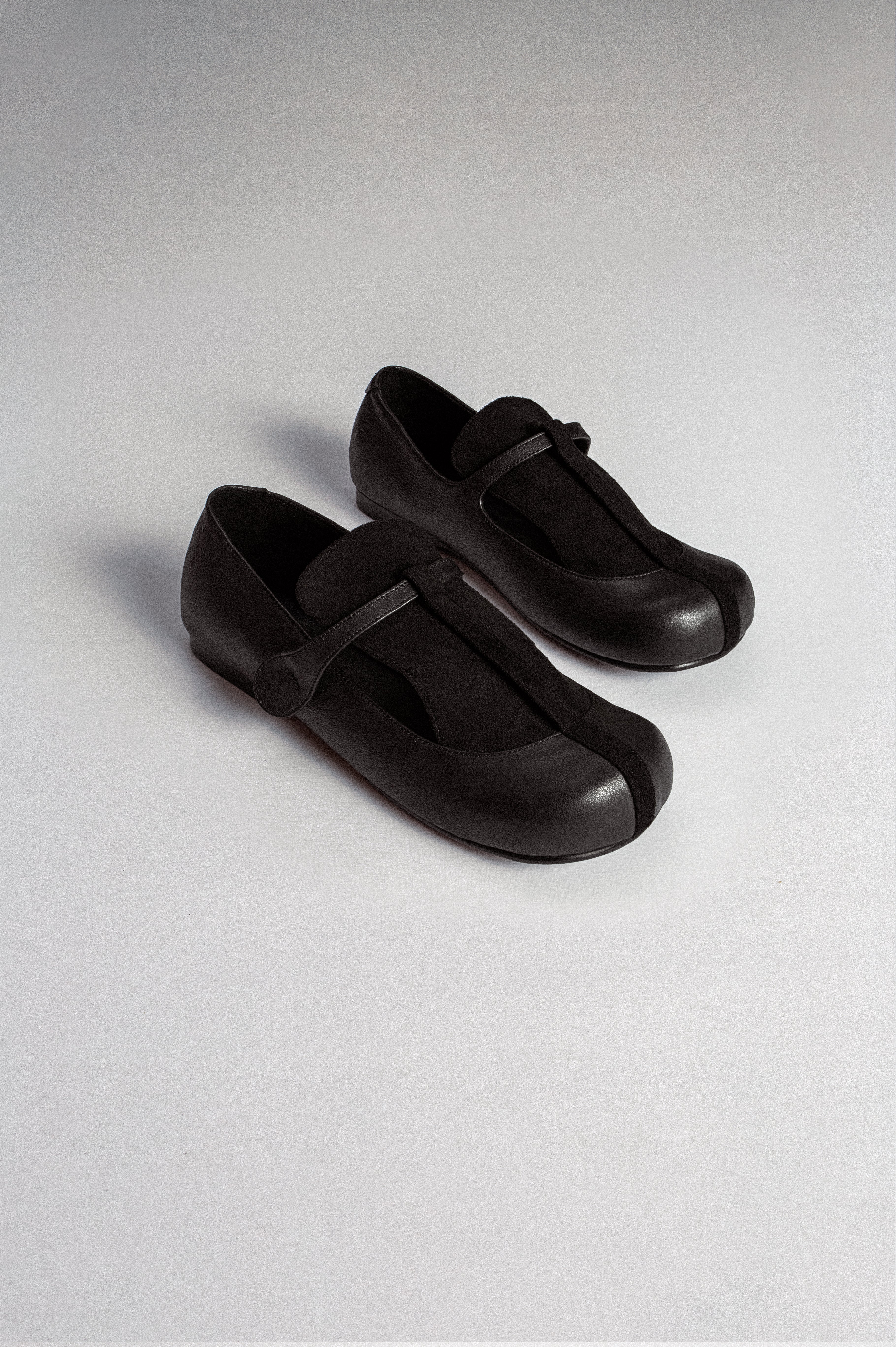 A pair of black leather flat shoes with a T-bar Mary Jane style from MTW.