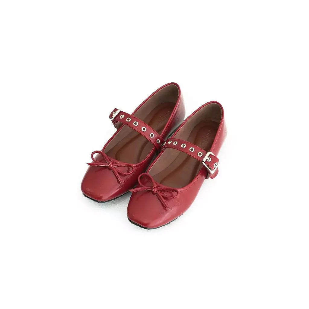 Red shoes with bow and buckle detail by Tangerine Marche on a white background