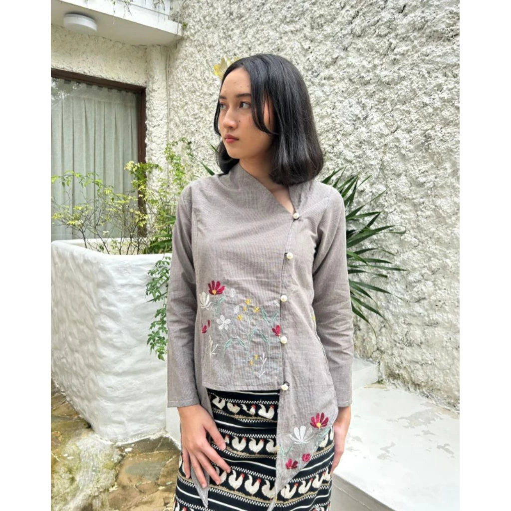 Woman wearing a gray embroidered tunic by Merona with a black and white patterned skirt outdoors.
Seorang wanita mengenakan tunik berhias bordir abu-abu dari Merona dengan rok bermotif hitam-putih di luar ruangan.