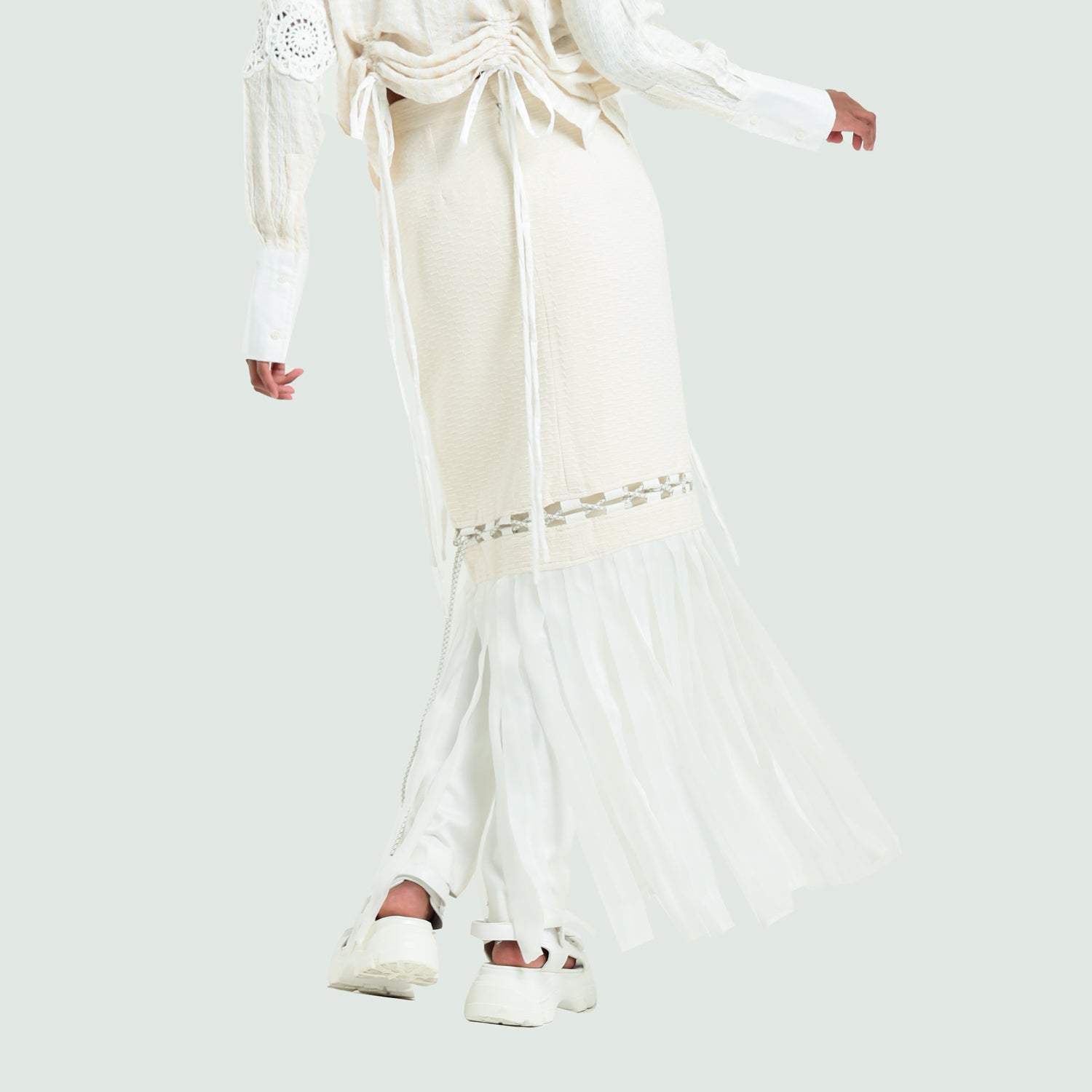 Broken white maxi skirt featuring a slim silhouette with decorative lace accents and flared sheer bottom.