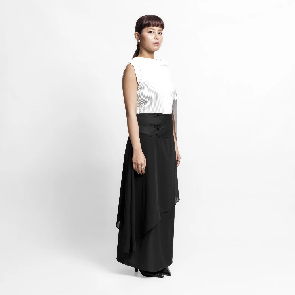 Person wearing a white top and black skirt by Isoos Studios on a white background