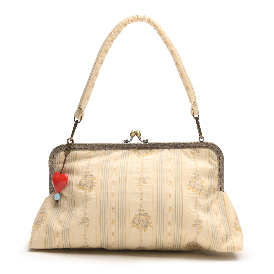 Beige women's handbag with floral pattern and red heart charm on a white background

Tas tangan wanita berwarna krem dengan motif bunga dan gantungan berbentuk hati merah di atas latar belakang putih