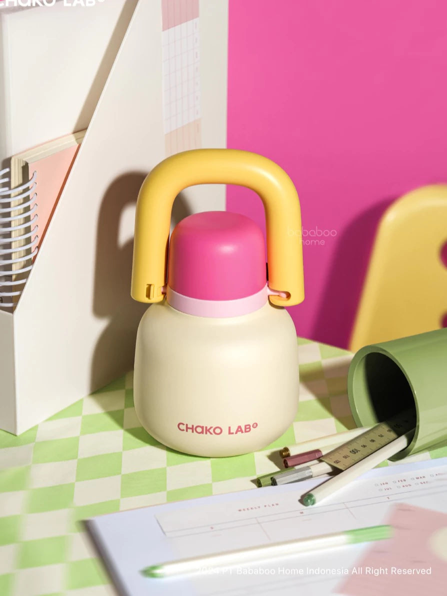 White and pink bottle with yellow handle from Chako Lab on a checkered surface
