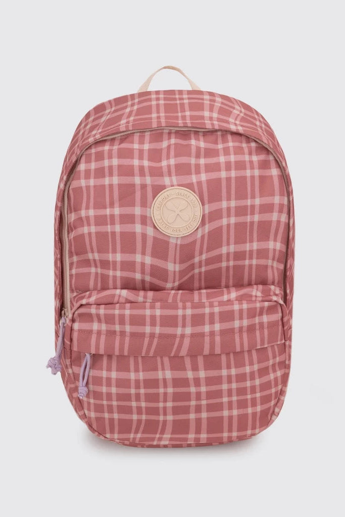 A pink and white plaid backpack by Exsport Bag with a circular beige logo patch on the front, photographed against a light gray background.