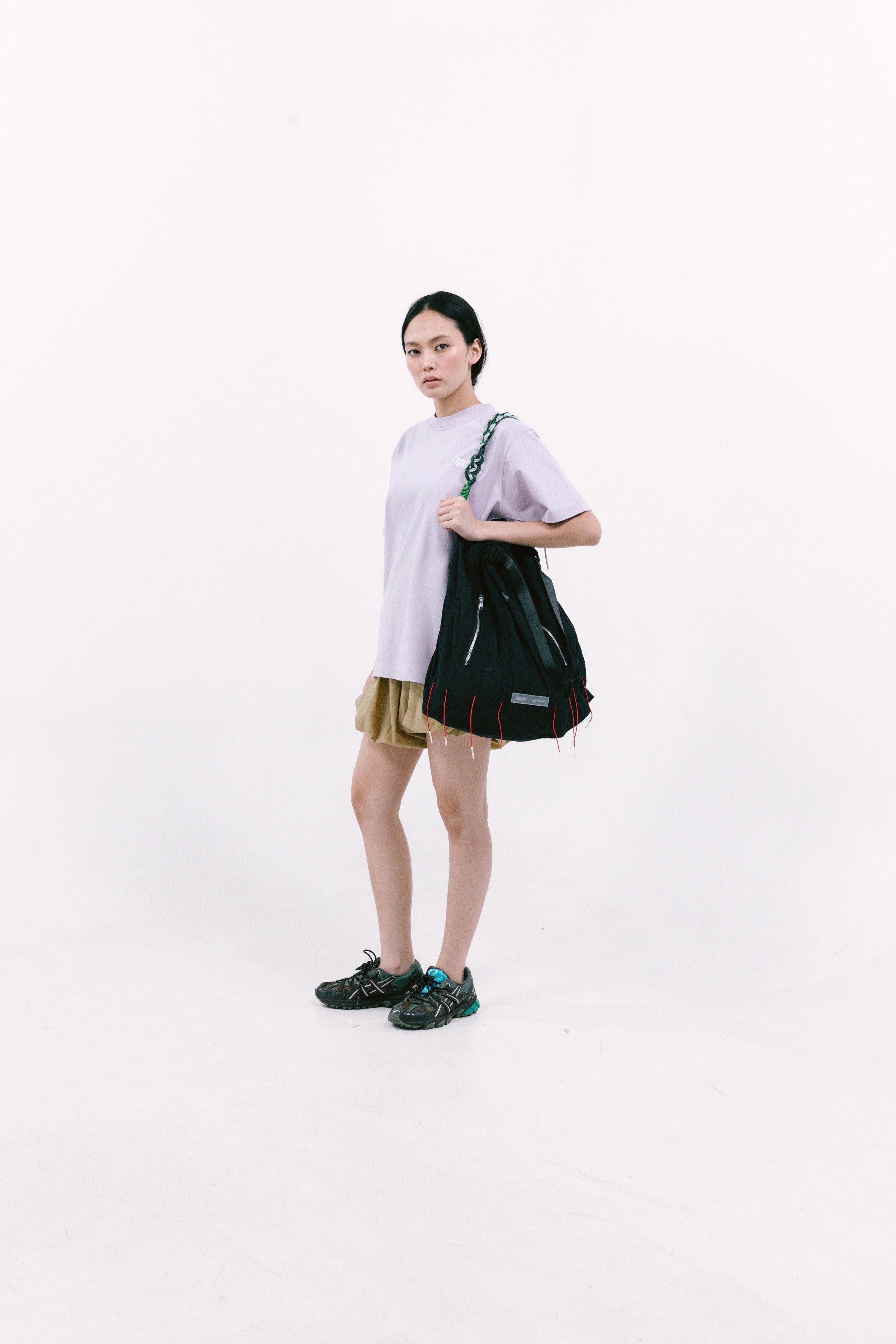 Person holding a black cuttlefish bag on a white background