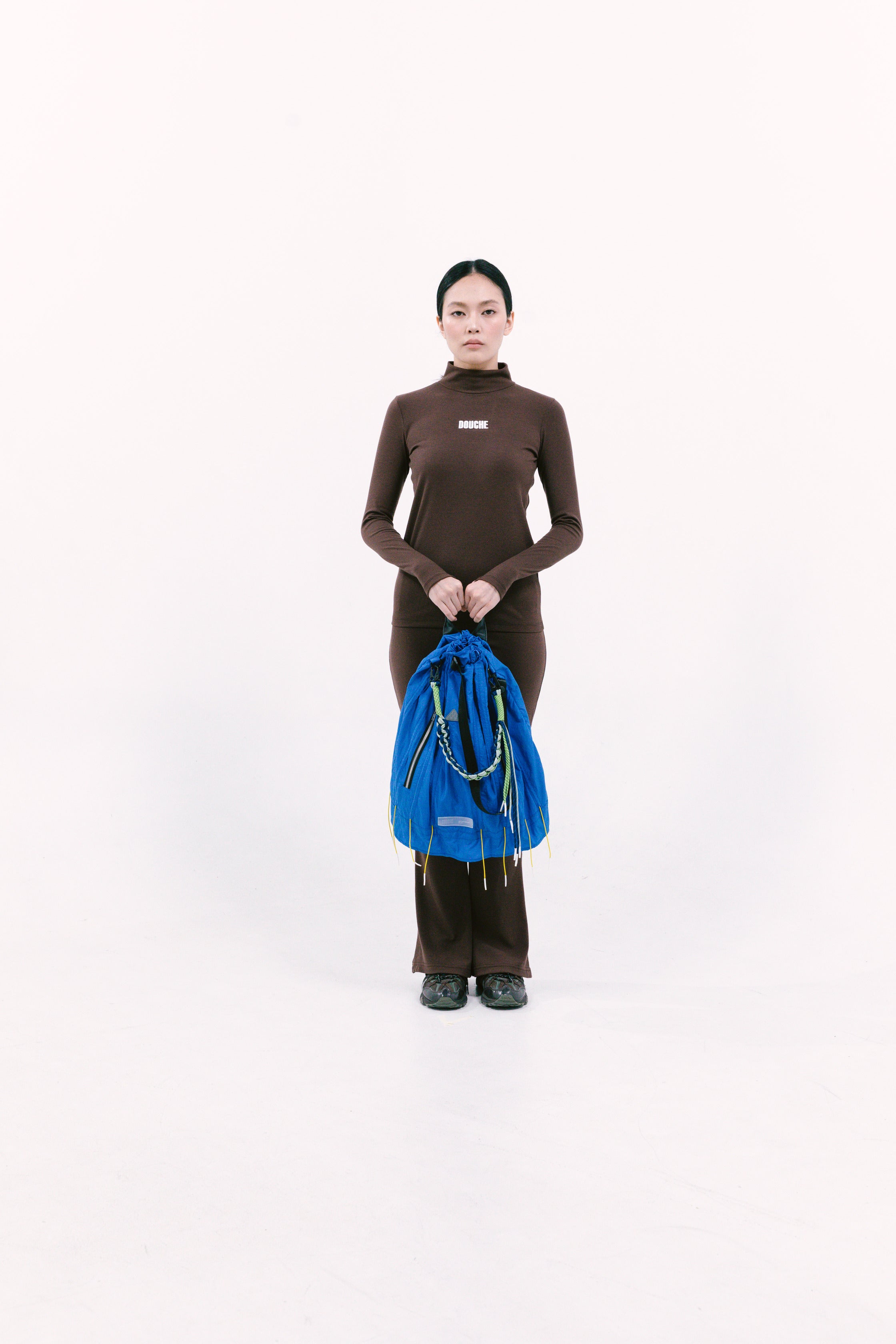 Person holding a blue cuttlefish bag against a white background