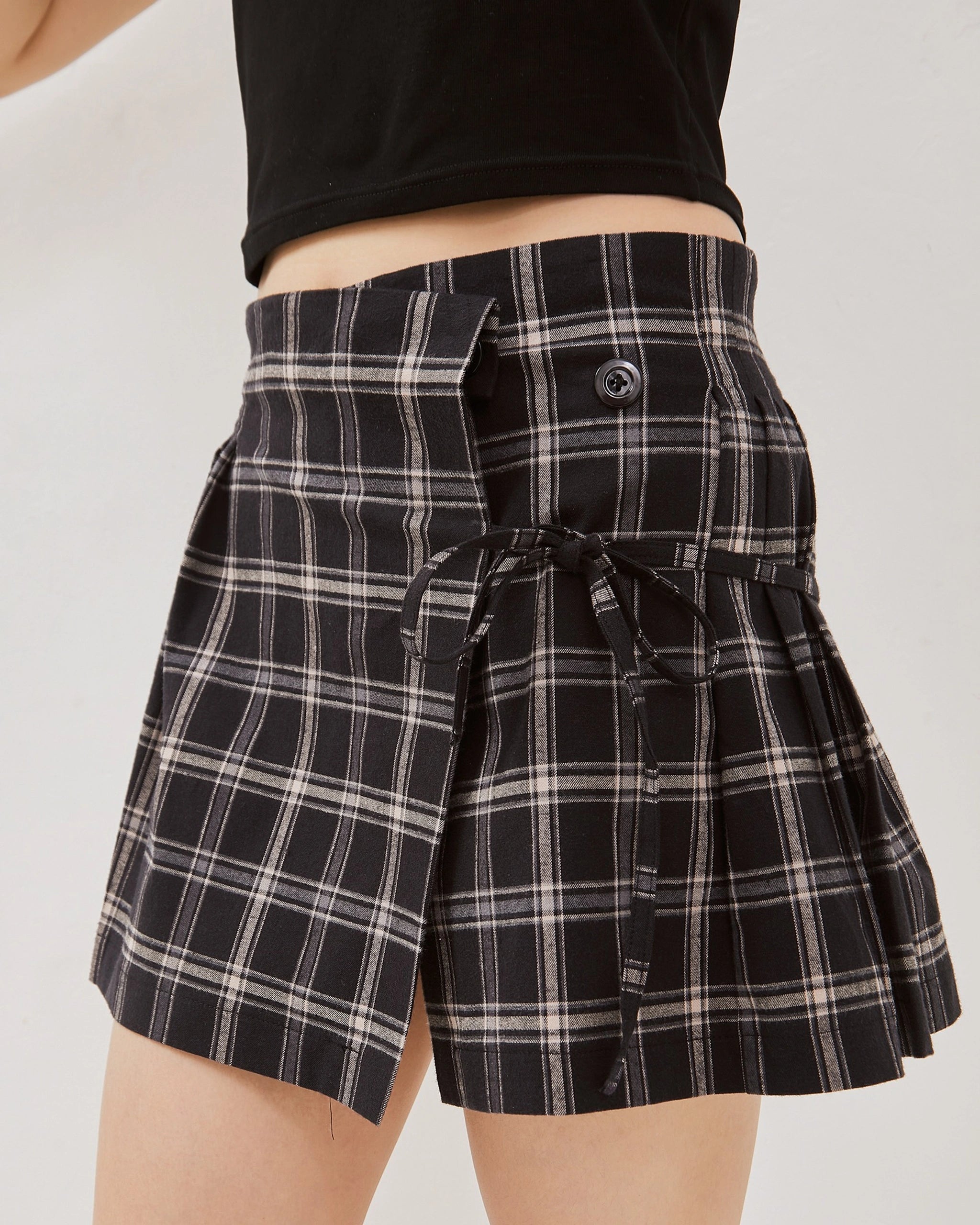 Black and white tartan mini skirt from Catha worn by a person on a plain background