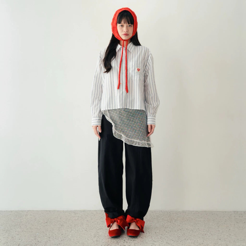 Person wearing a white striped shirt by notyourcompany with a red hood, black pants, and red shoes on a plain background