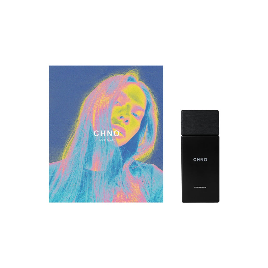A Saff n Co perfume bottle with a colorful abstract design featuring a woman's face, and the brand name 'CHNO' on the cap. The bottle is black with a blue label.