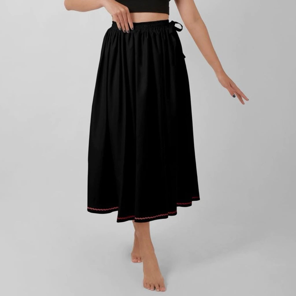 Black skirt with red trim worn by a person on a gray background