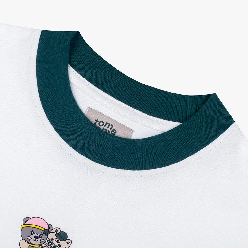 Close-up of a white shirt with green collar and 'tome ame' brand label on a white background.