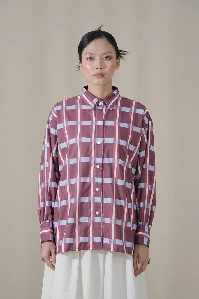 Person wearing a red and white checkered shirt by Tuff Puff against a beige background