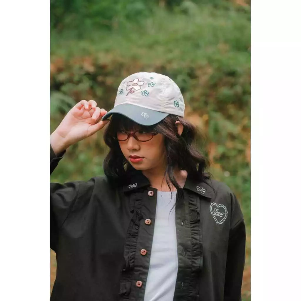 Person wearing a cap with floral patterns by Tome Ame