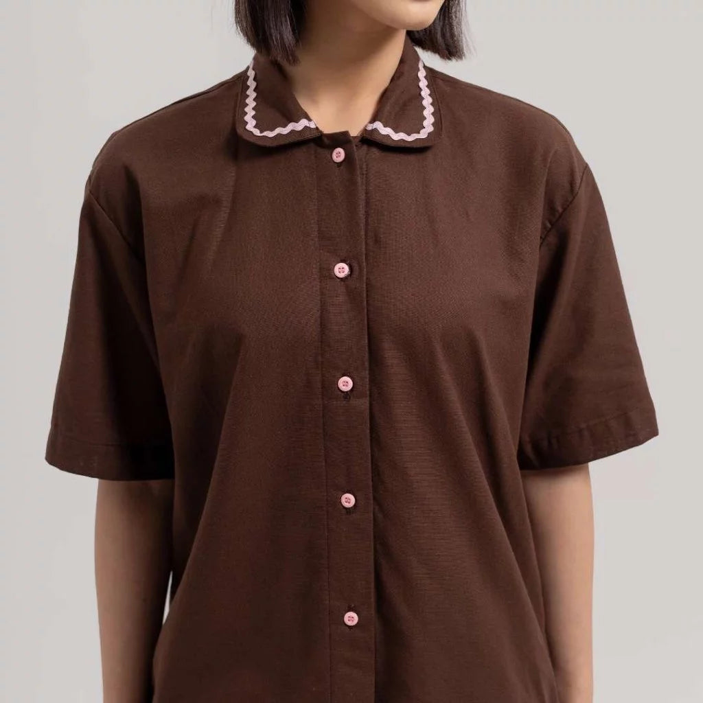 Brown linen shirt by Tuff Puff with pink buttons and trim on a plain background