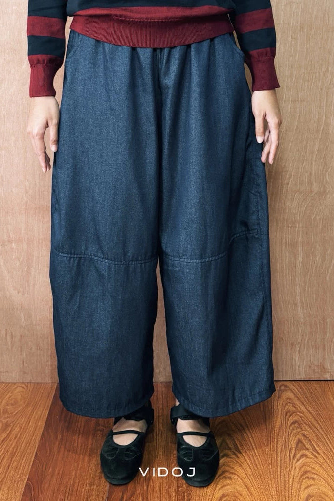 Person wearing blue barrel pants denim and a striped shirt against a wooden background

Seseorang mengenakan celana barrel berwarna biru denim dan kemeja bergaris dengan latar belakang kayu