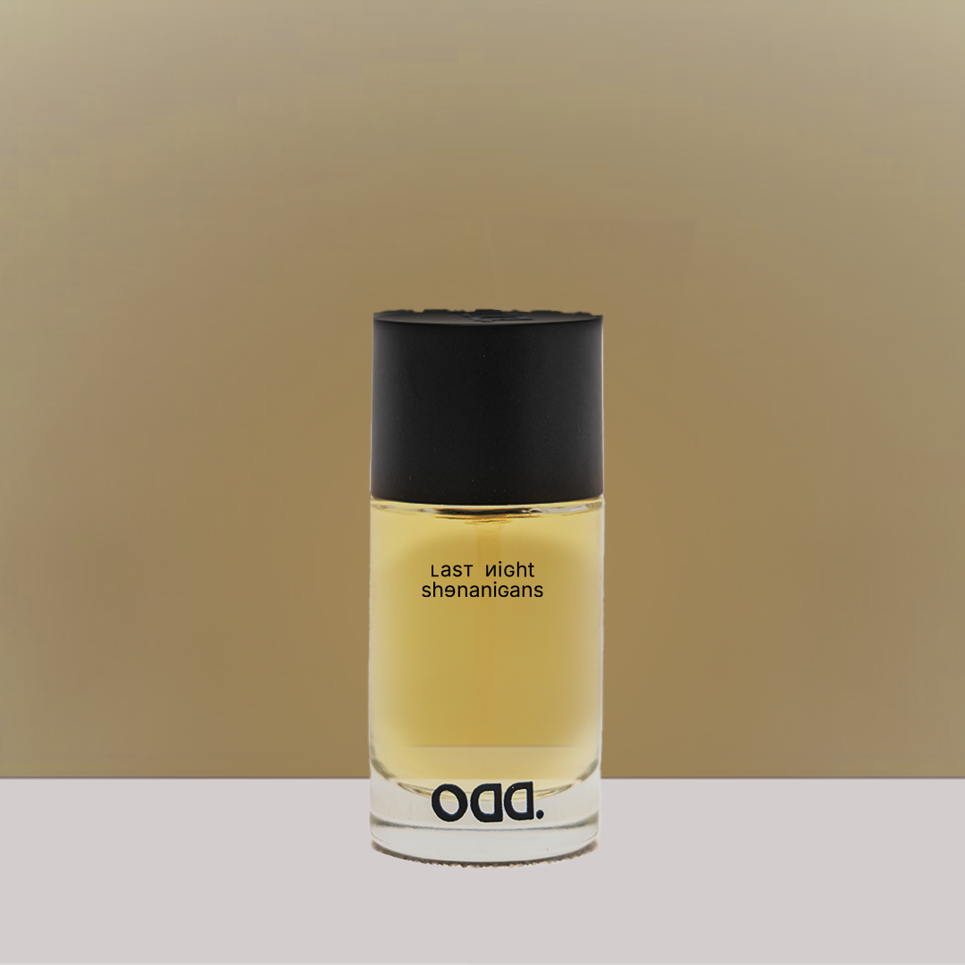 A bottle of perfume with a clear liquid visible inside, labeled 'Last night shenanigans' by brand ODD.