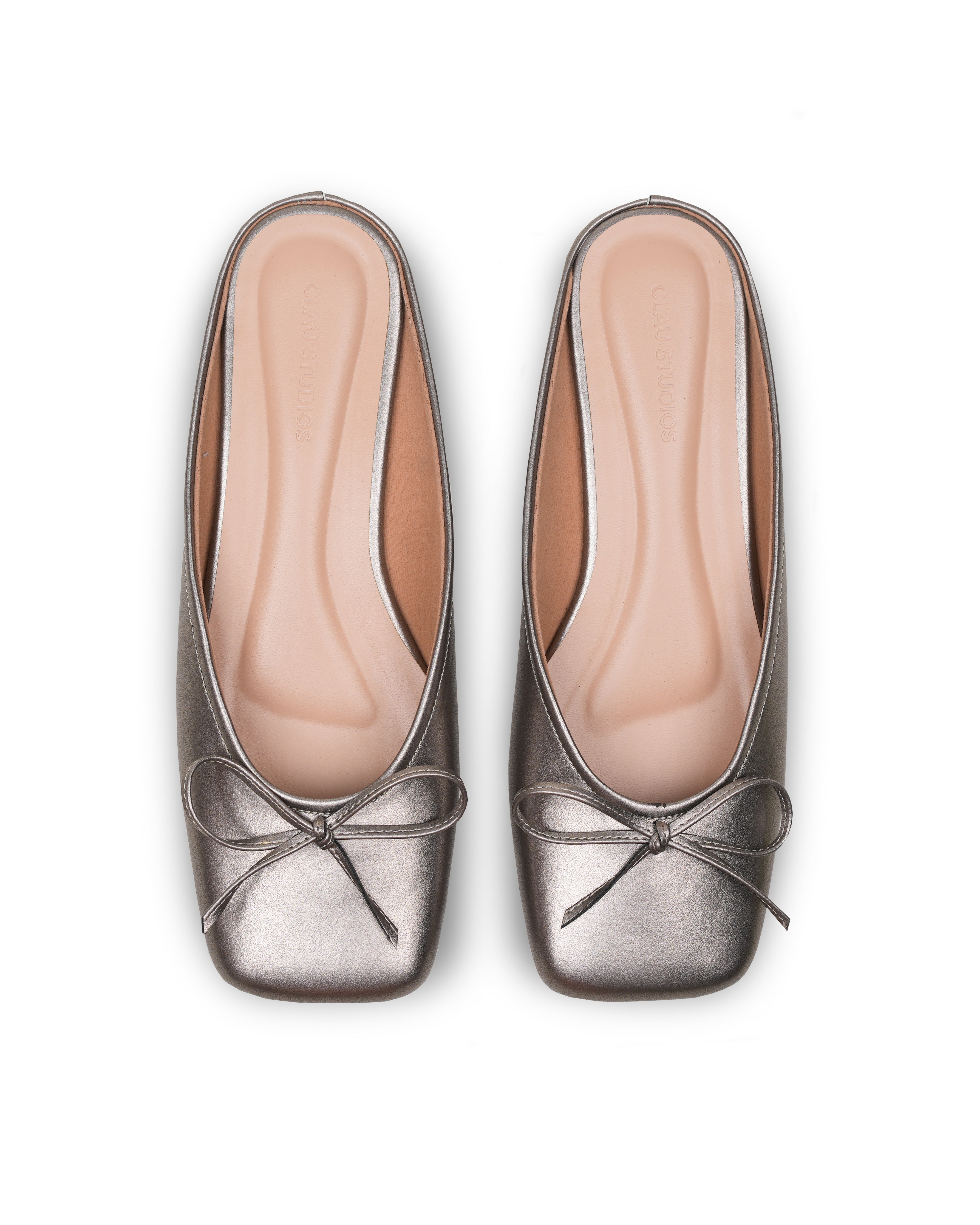 Pair of metallic silver flat shoes with a bow details on a white background