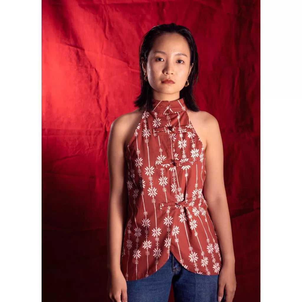 Woman wearing a red sleeveless floral batik by Manikan against a red background