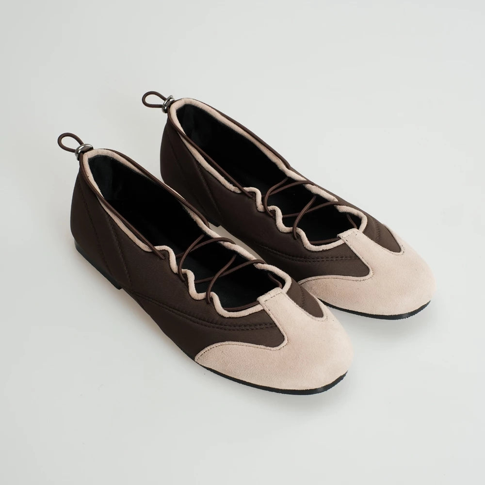 Pair of brown and pink flatshoes on a light gray background